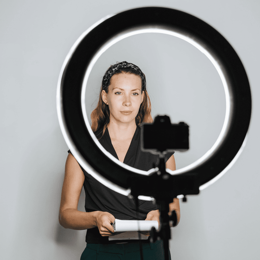 woman using a ring light and tripod stand with her camera